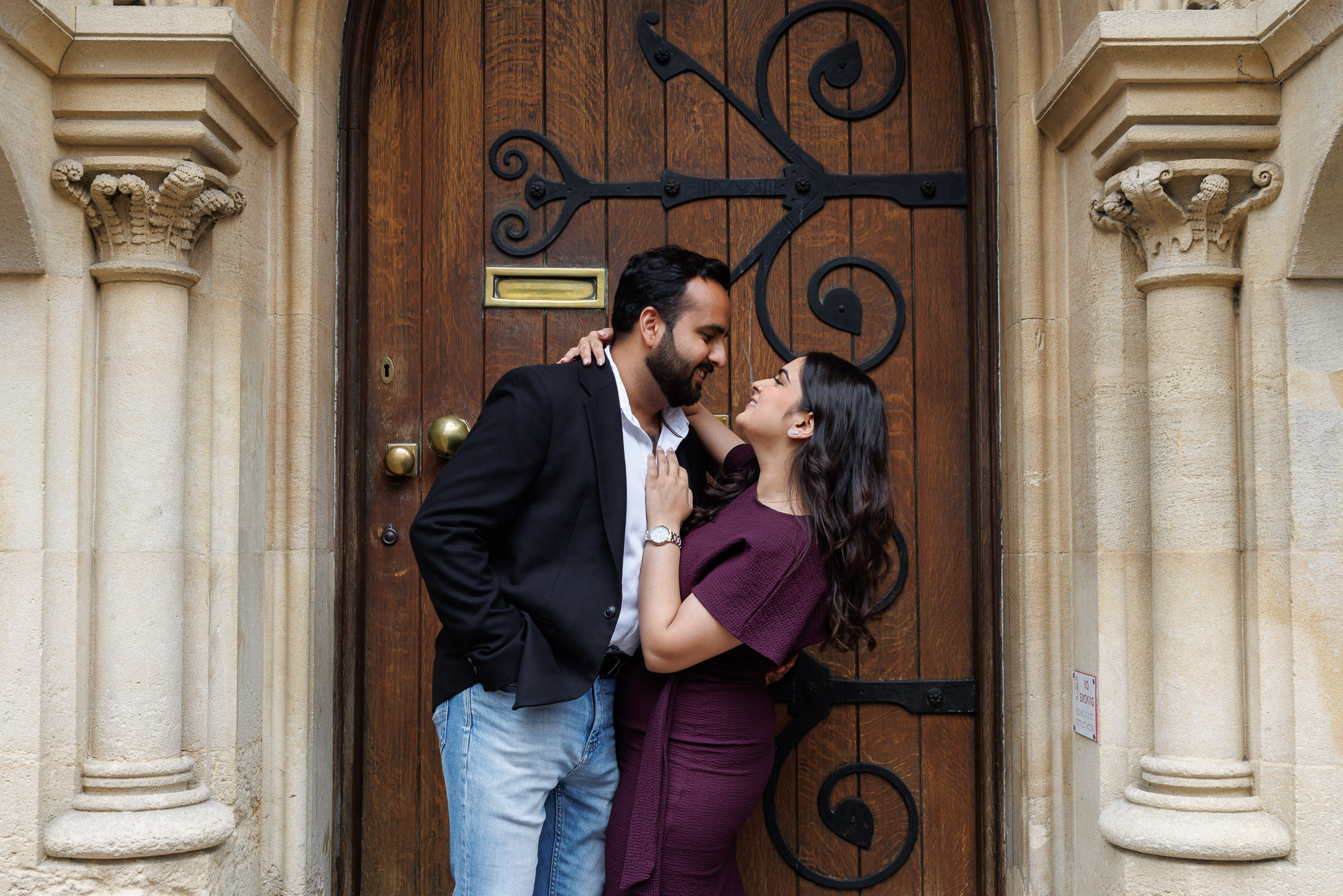 Engaged couple laughing together during Oxford University engagement photography session