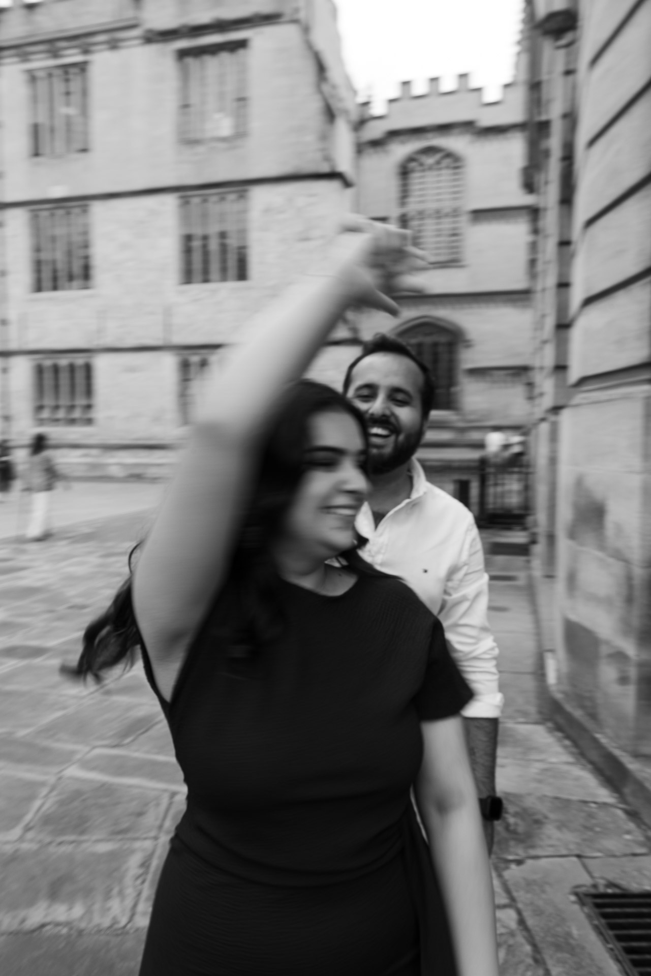 Engaged couple laughing together during Oxford University engagement photography session