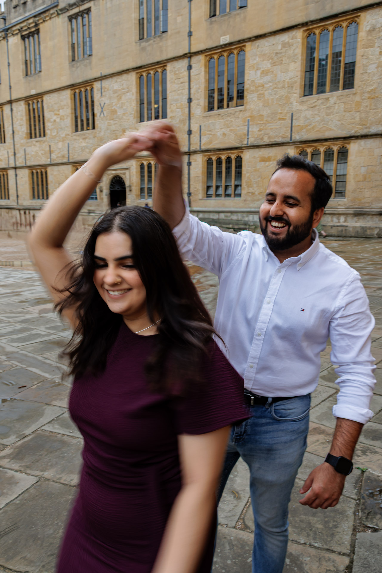 Engaged couple laughing together during Oxford University engagement photography session